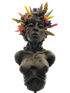 a statue with many different colored objects on it's head and torso, against a white background