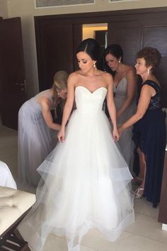 the bride is getting ready to walk down the aisle in her white wedding dress with sheer tulle