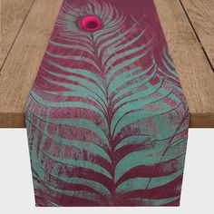 a skateboard sitting on top of a wooden floor next to a red object in the shape of a feather