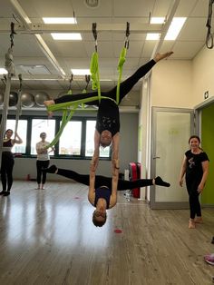 some people are doing acrobatic tricks in a gym