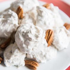 a white plate topped with meringue and pecans on top of a table