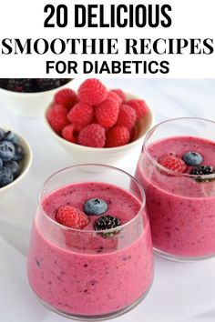 two glasses filled with smoothie next to bowls of berries and blueberries on a white table