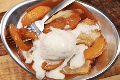 a bowl filled with fruit and ice cream on top of a wooden table