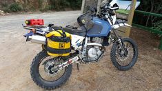 a motorcycle parked on the side of a dirt road