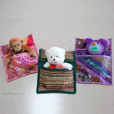 three stuffed animals are sitting in small bags