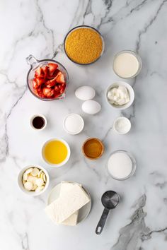 ingredients to make strawberry shortcakes laid out on a marble counter top