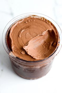 a cup filled with chocolate frosting on top of a table