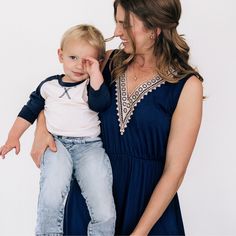 WOMEN'S- Mom's knee length dress is made with silky soft navy blue cotton like fabric with a small percent of spandex making them stretchy and comfortable. Convenient side pockets, a stretchy elastic waist for an easy pullover fit, and an elegant off-white lace accent adorns the bust of each dress. . SON- Dress your sweet boy in a smart 3/4 length sleeved shirt. The navy and light beige color creates the perfect matching piece to go with the women's dress for a mommy and son set you will love getting complimented on. Perfectly coordinated outfits for your next family photoshoot! Blue Cotton Dress With Elastic Waistband, Mommy Son, Coordinated Outfits, Soft Navy Blue, Day At The Park, Mommy And Me Dresses, Mama Necklace, Mommy And Son, Mother Child