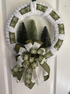 a wreath hanging on the front door decorated with snowflakes and christmas trees,