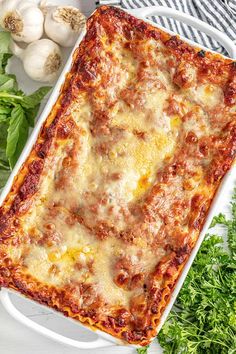 a square casserole dish filled with meat and cheese next to fresh parsley