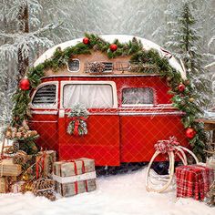 an old red bus with christmas decorations and presents in the snow near evergreens, pine cones and fir trees