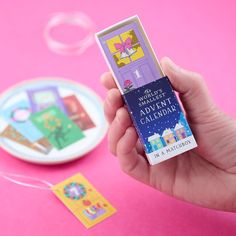 someone is holding up a card game in front of a plate and other items on the table