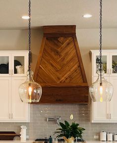 a kitchen with two hanging lights over the stove