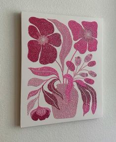 a pink and white painting with flowers on the wall in front of a white wall