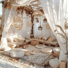 a room with lots of pillows and curtains on the ceiling, covered in white drapes