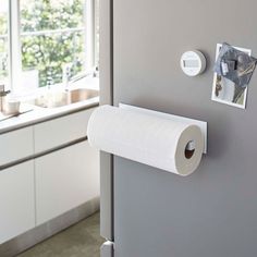 a roll of toilet paper hanging on the side of a refrigerator