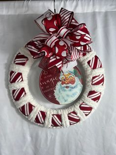 a red and white christmas ornament hanging on a wall