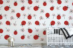 a baby's room with a white crib and red ladybugs on the wall