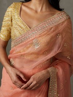 Editor's Note Elevate your traditional style with our coral/yellow machine and hand-embroidered sterling sari, complete with a stitched blouse. This ensemble is perfect for special occasions, allowing you to showcase timeless elegance with intricate embroidery and the convenience of a pre-stitched blouse. Make a lasting impression at any event with this classic and sophisticated attire that combines tradition with modern comfort. Fabric: Silk organza Color: Coral Components: Sari and blouse Occa Traditional Chinon Blouse With Dupatta, Traditional Peach Pre-draped Saree With Zari Work, Traditional Drape Blouse With Dupatta In Chinon, Fitted Pre-draped Saree With Intricate Embroidery For Festivals, Gold Dola Silk Blouse With Dupatta, Festive Pre-draped Cotton Silk Saree With Intricate Embroidery, Transitional Designer Yellow Pre-draped Saree, Tissue Silk Blouse With Dupatta For Transitional Season, Bollywood Style Cotton Silk Blouse Piece For Wedding