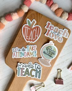 a wooden cutting board with some stickers on top of it next to other items