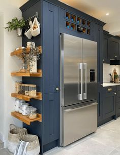 a kitchen with blue cabinets and stainless steel appliances