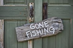 a wooden sign that says gone fishing on it