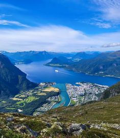 the view from the top of a mountain looking down at a lake and mountains