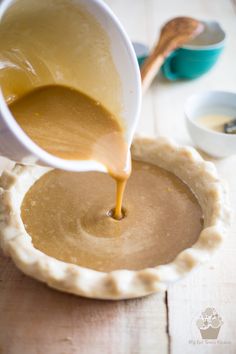 a person pouring batter into a pie crust