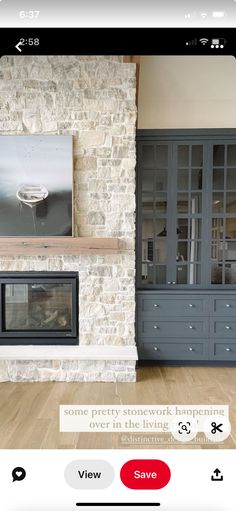 a living room filled with furniture and a fire place in front of a stone wall