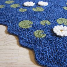 a crocheted blue rug with white flowers on it