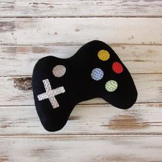 a close up of a game controller on a wooden surface with paint splatters