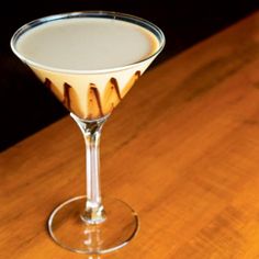 a glass filled with liquid sitting on top of a wooden table