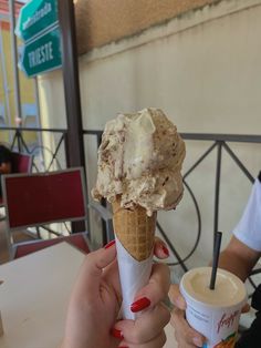 two people holding ice cream cones in their hands