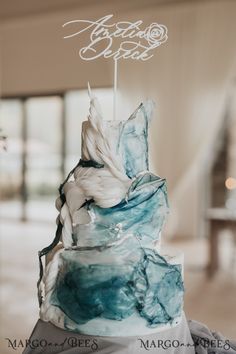 a blue and white cake sitting on top of a table