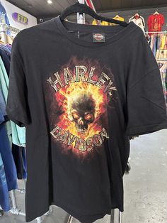 a black harley davidson t - shirt hanging on a rack in a clothing department store