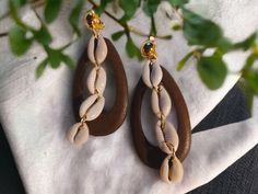 These are unique and natural  Natural wood hoopd cowrie shells  One of a kind 100% handmade They hang 3 inches large size These are very lightweight on the ear Easy to wear They are one of a kind These Earrings are a unique and abstract addition to any wardrobe *all handpainted designs are original and may slightly differ due to artistic original Trendy Brown Earrings For Beach, Trendy Brown Beach Jewelry, Handmade Cowrie Shell Earrings As Gift, Handmade Cowrie Shell Earrings For Gift, Trendy Brown Vacation Jewelry, Bohemian Brown Cowrie Shell Jewelry, Brown Teardrop Earrings For Beach, Brown Teardrop Earrings For The Beach, Handmade Brown Cowrie Shell Jewelry