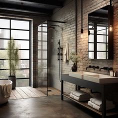 an industrial bathroom with brick walls and flooring, exposed lighting, large windows, and a free standing tub