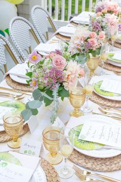 the table is set with place settings and flowers in vases, plates, and napkins