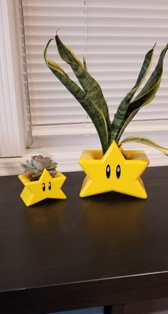 two yellow star shaped planters sitting on top of a table