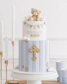 there is a blue and white cake with gold decorations on the top that has a teddy bear in it