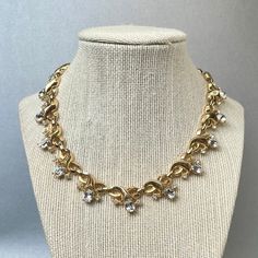 "Vintage 1940s Crown Trifari Choker, Gold Tone Clear Oval Rhinestones Necklace, Alfred Phillipe Signed MidCentury Modern Jewelry, Gift for Her. Era: 1940. Designer: Crown Trifari Pat Pend.( It have been Designed by Alfred Phillipe) Measurements: - Length of Chain: 16\" inches. - Width: 3/4\" inch. Details: - Metal Color: Gold. - Embellishments: Gold Tone Plating with a little patina, Clear Oval 8 x6mm Rhinestones, Clear round Rhinestones, an Infinity Ornament, Choker necklace. - Closure: Fold Ov 1950s Jewelry Gold, 1940s Jewelry Style, Vintage Diamond Necklaces For Evening, Vintage Necklace With Diamond Accents For Evening, Vintage Jeweled Oval Necklace, Vintage Oval Jeweled Necklaces, Vintage Oval Jeweled Necklace, Vintage Oval Necklace With Diamond Accents, Vintage Formal Necklaces With Diamond Accents