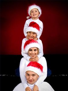 a group of people wearing santa hats on top of each other