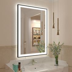 a bathroom sink with a large mirror above it and flowers in the vase on the counter