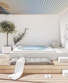 an outdoor jacuzzi tub in the middle of a wooden floored patio area