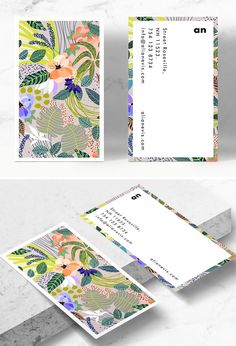 two business cards with colorful flowers and leaves on them, one has a white envelope