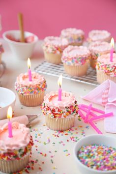 cupcakes with pink frosting and sprinkles on a table