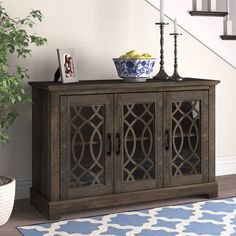 a wooden cabinet sitting next to a stair case on top of a blue and white rug