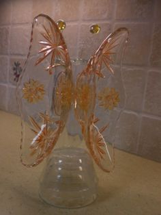 a clear glass vase sitting on top of a counter next to a white brick wall