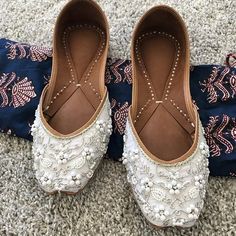 two pairs of shoes sitting on top of a carpet