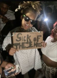 a woman holding a sign that says sick of the hell